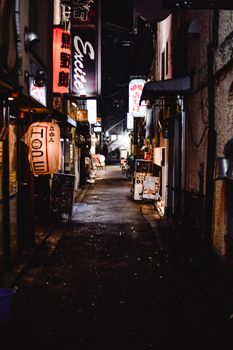 日本京都一条狭窄的小巷里，夜晚的灯笼和标牌灯光精美，捕捉到了日本夜生活的精髓