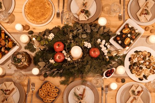 Free A beautifully decorated holiday dinner table with candles, festive dishes, and a Christmas centerpiece. Stock Photo