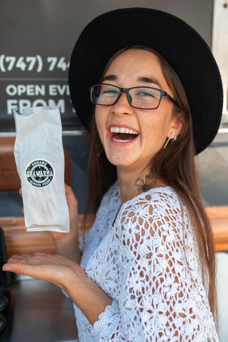 Woman In White Top Holding A Shawarma