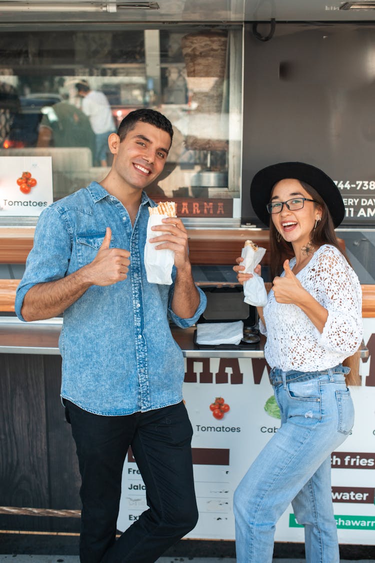 A Man And Woman Eating Shawarma