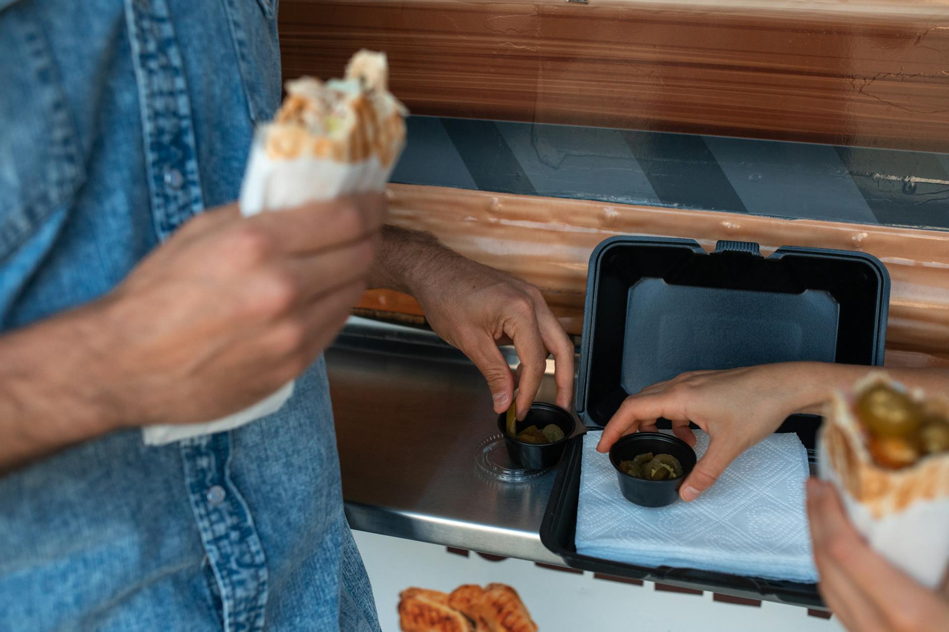 https://www.pexels.com/photo/close-up-shot-of-a-person-holding-a-shawarma-5779419/