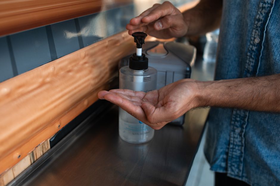 Person dispensing rubbing alcohol from a pump bottle — removing tree sap from clothing Surrey BC