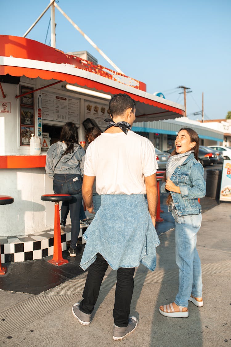 Friends Catching Up Near A Food Stall 