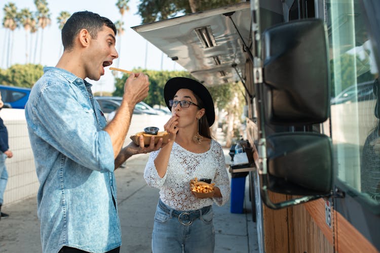 Friends Eating Fries Beside A Food Truck 