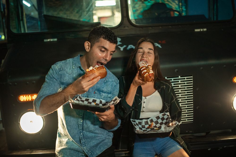 Friends sharing truck food together in front of the Fuego Seoul truck
