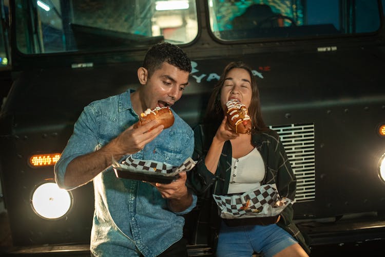 Man And Woman Eating In Front Of The Food Truck