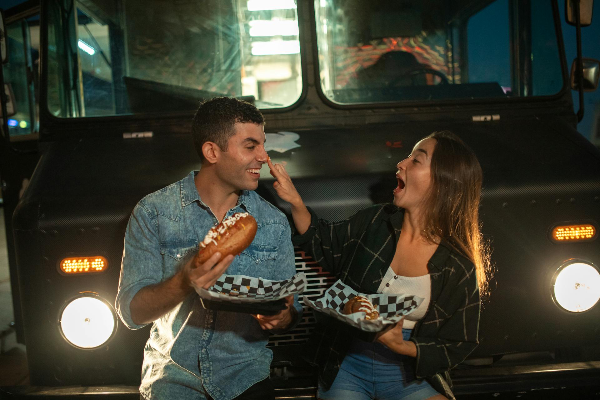 Man and Woman Eating in Front of the Food Truck