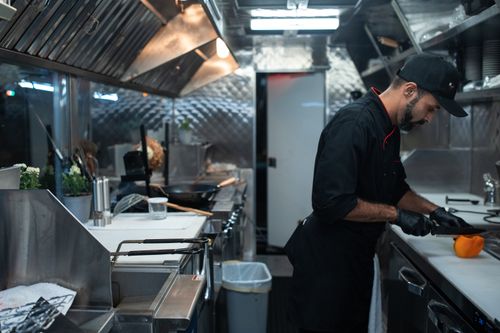 Free Chef in a modern kitchen cutting vegetables, showcasing culinary skills. Stock Photo