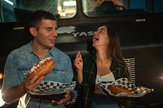 A joyful couple sharing street food at a night market food truck.