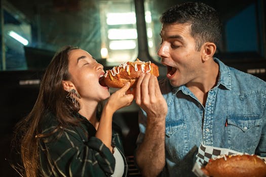 Happy couple sharing a delicious hot dog from a food truck.