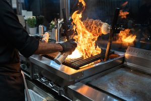 Chef grilling with flames in a modern kitchen — RDNE Stock project on Pexels