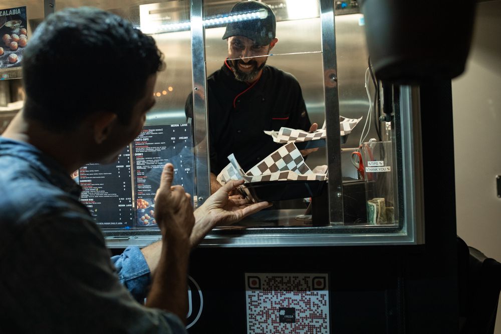 A Fuego Seoul cook passing a fresh order through the truck hatch