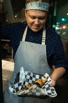 Man in apron presenting a freshly grilled skewer with vegetables and meat from a food truck.