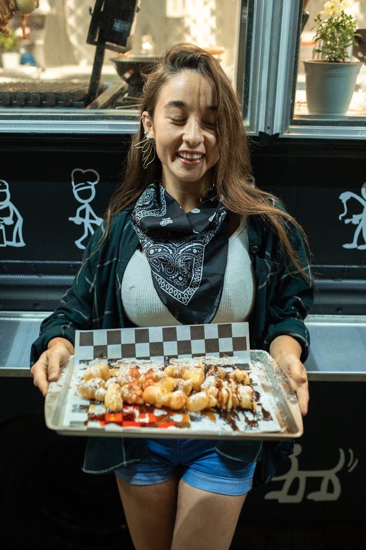 Woman Holding A Tray Of Beignet Fritters 