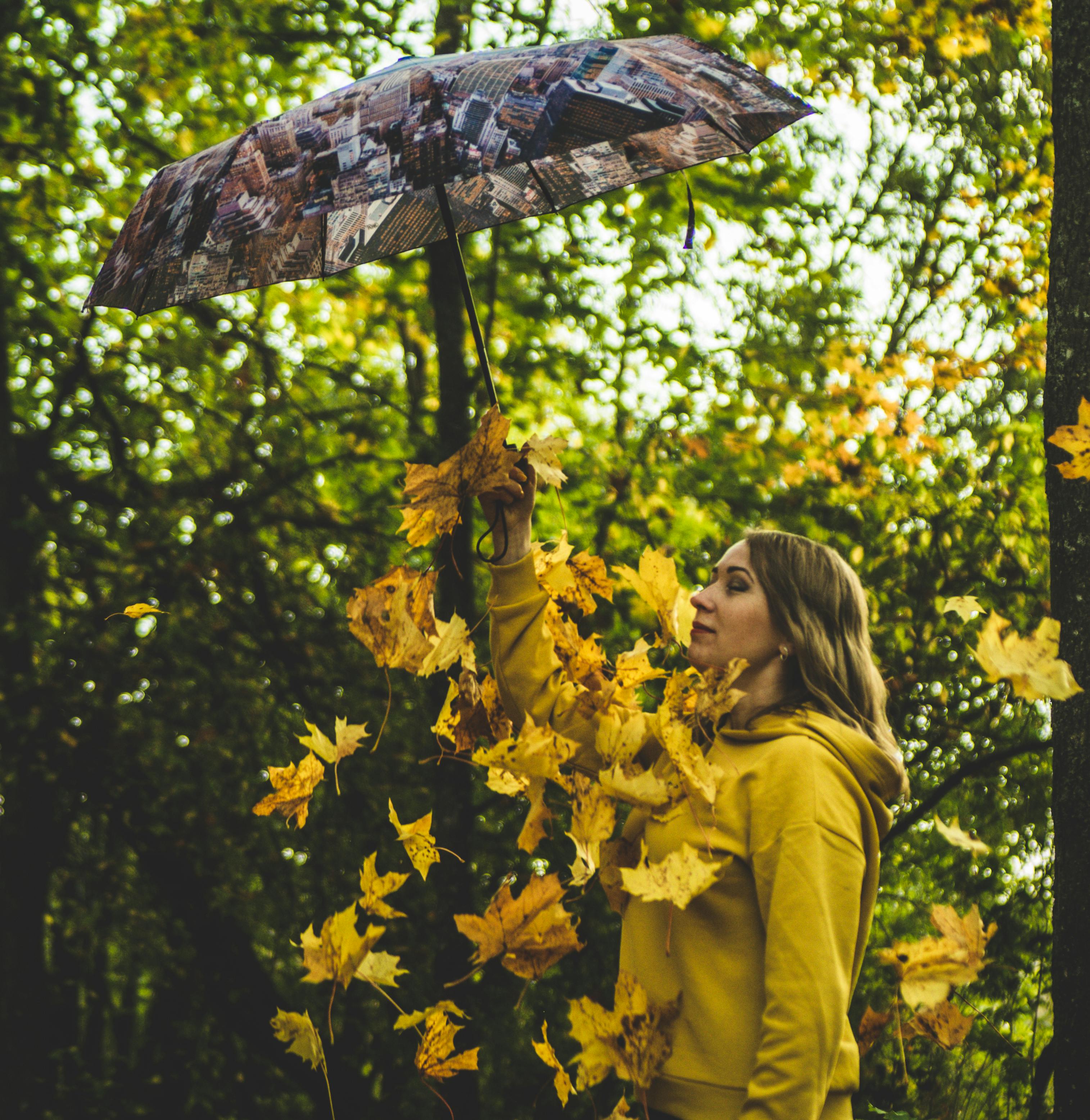 woman in yellow jacket holding umbrella