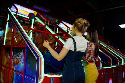 Two women playing an arcade basketball game, having fun together.