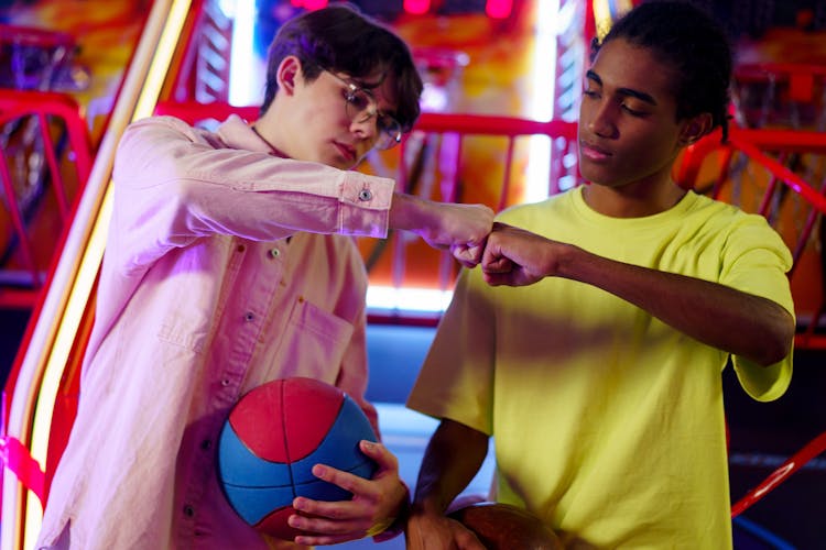 Men Fist Bumping In An Amusement Center