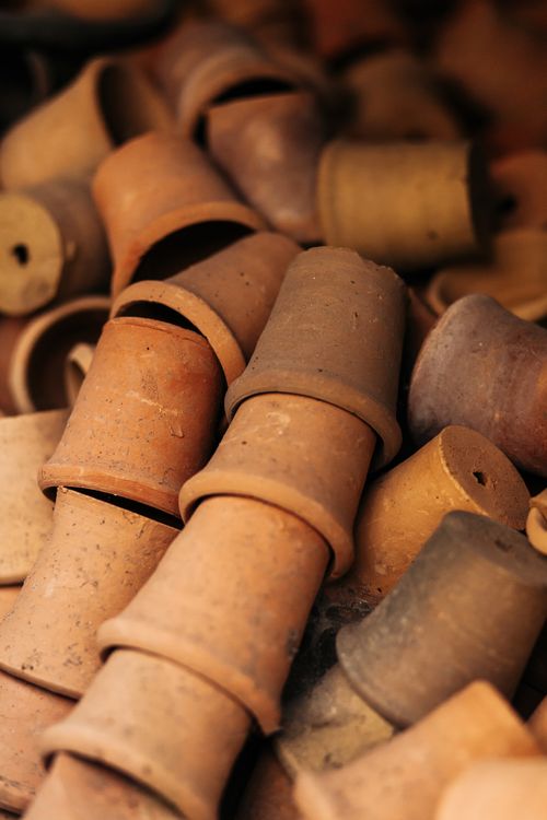 Free A collection of handmade clay pots stacked in a rustic, artistic arrangement showcasing natural clay textures. Stock Photo