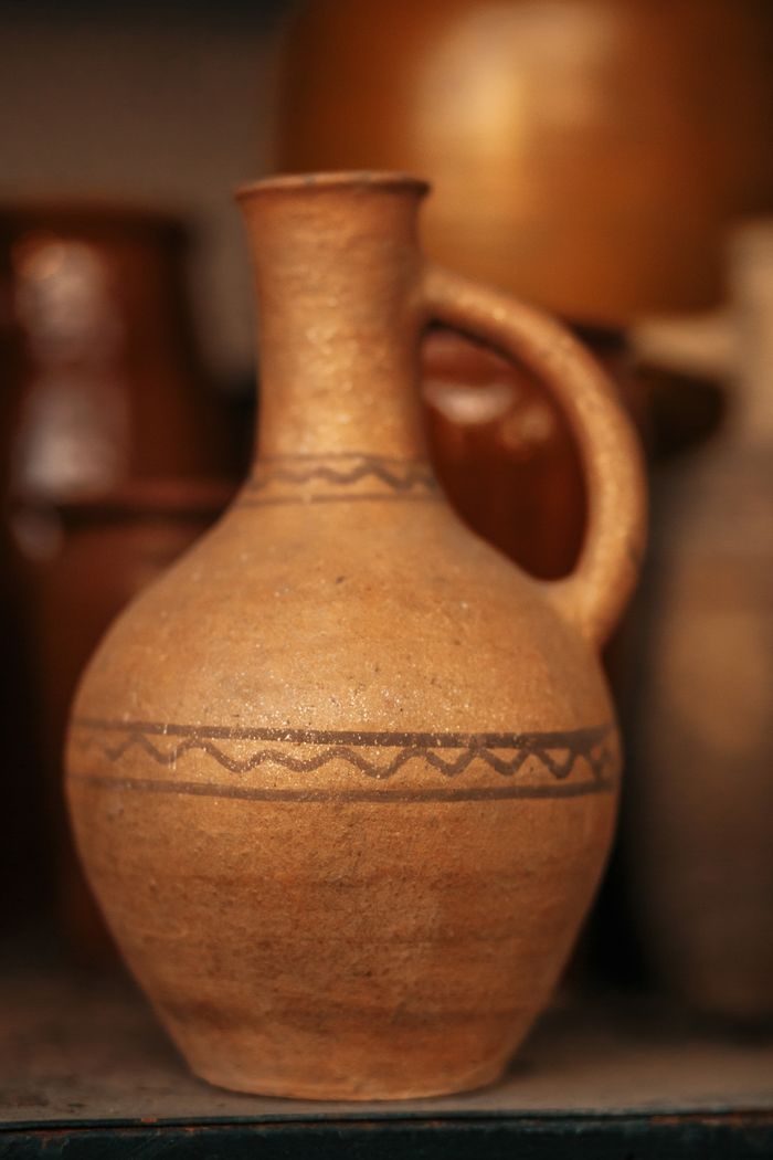 Handcrafted clay jug with incised banding on a shelf — photo by Anna Khomutova on Pexels