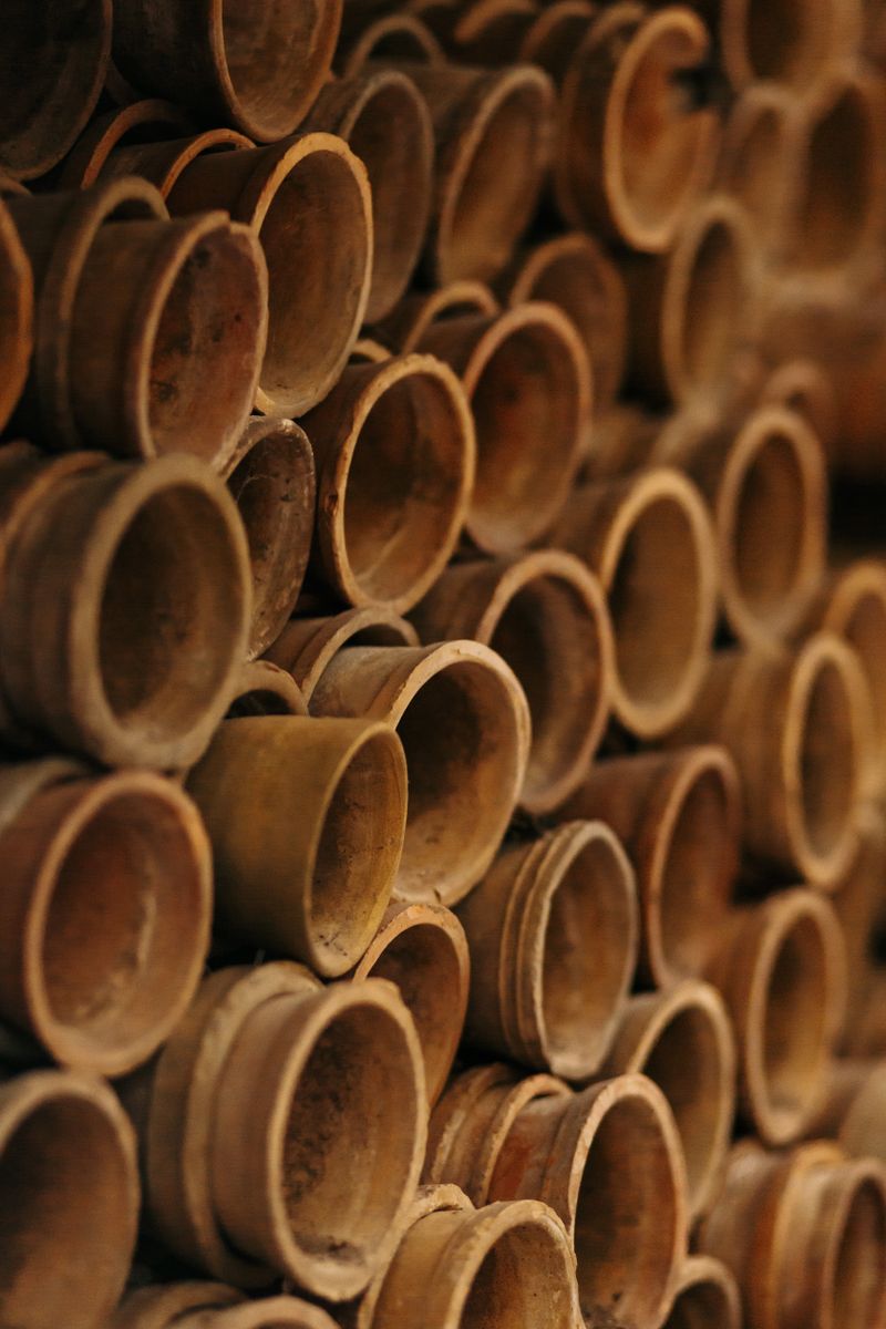 Stacks of unfired clay pots drying on a studio shelf