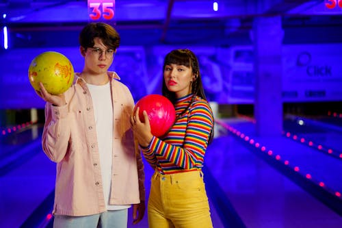 Two Young People holding Bowling Balls
