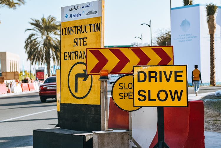 Road In Modern City With Yellow Warning Traffic Signs