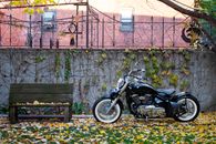 Black Motorcycle Parked Beside Brown Wooden Bench