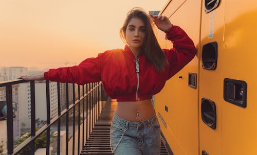 Young woman standing near metal fence