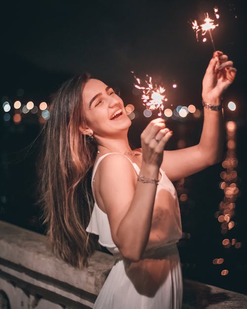 Woman in White Dress Holding Sparklers