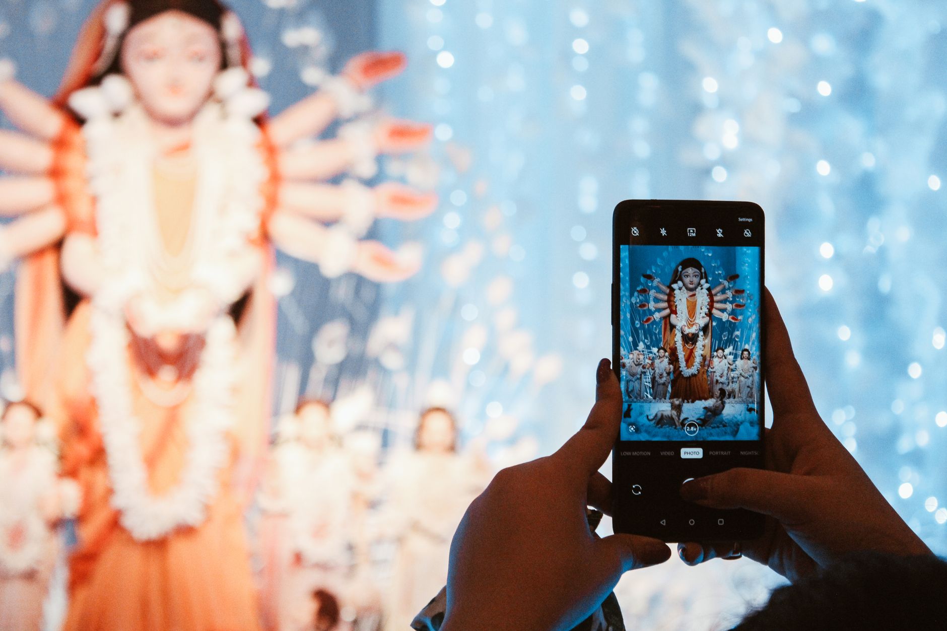 नवरात्रि सजावट के बीच स्मार्टफोन पर तीन पत्ती टूर्नामेंट लॉबी देखते खिलाड़ी का शांत घरेलू दृश्य