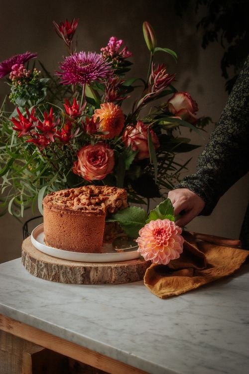 Free Brown Cake beside a Flower Arrangemet Stock Photo