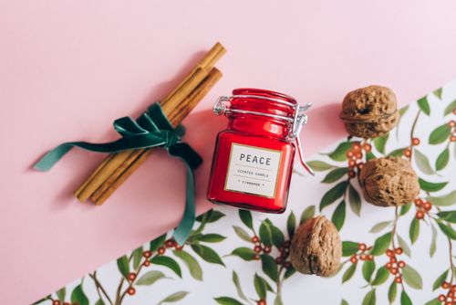 Free Festive composition with a red scented candle, cinnamon sticks, and walnuts. Stock Photo
