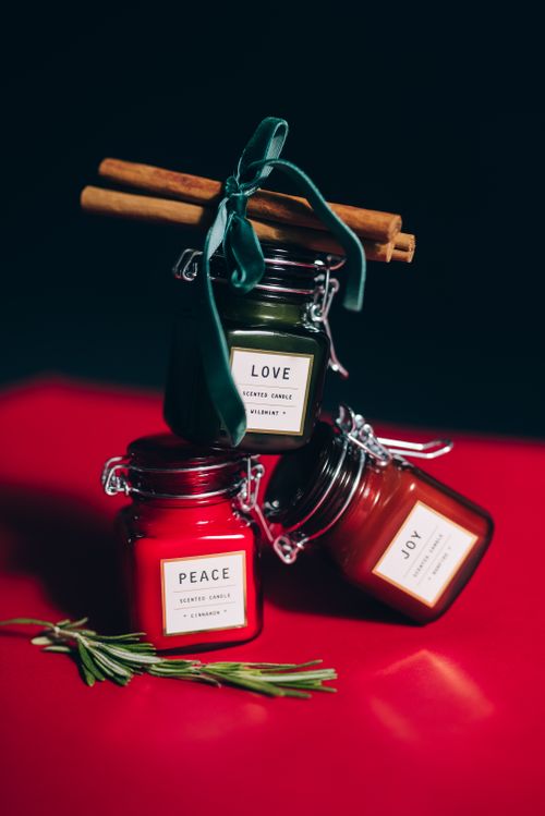 Free Holiday-themed candles with cinnamon and rosemary for warm ambiance. Stock Photo