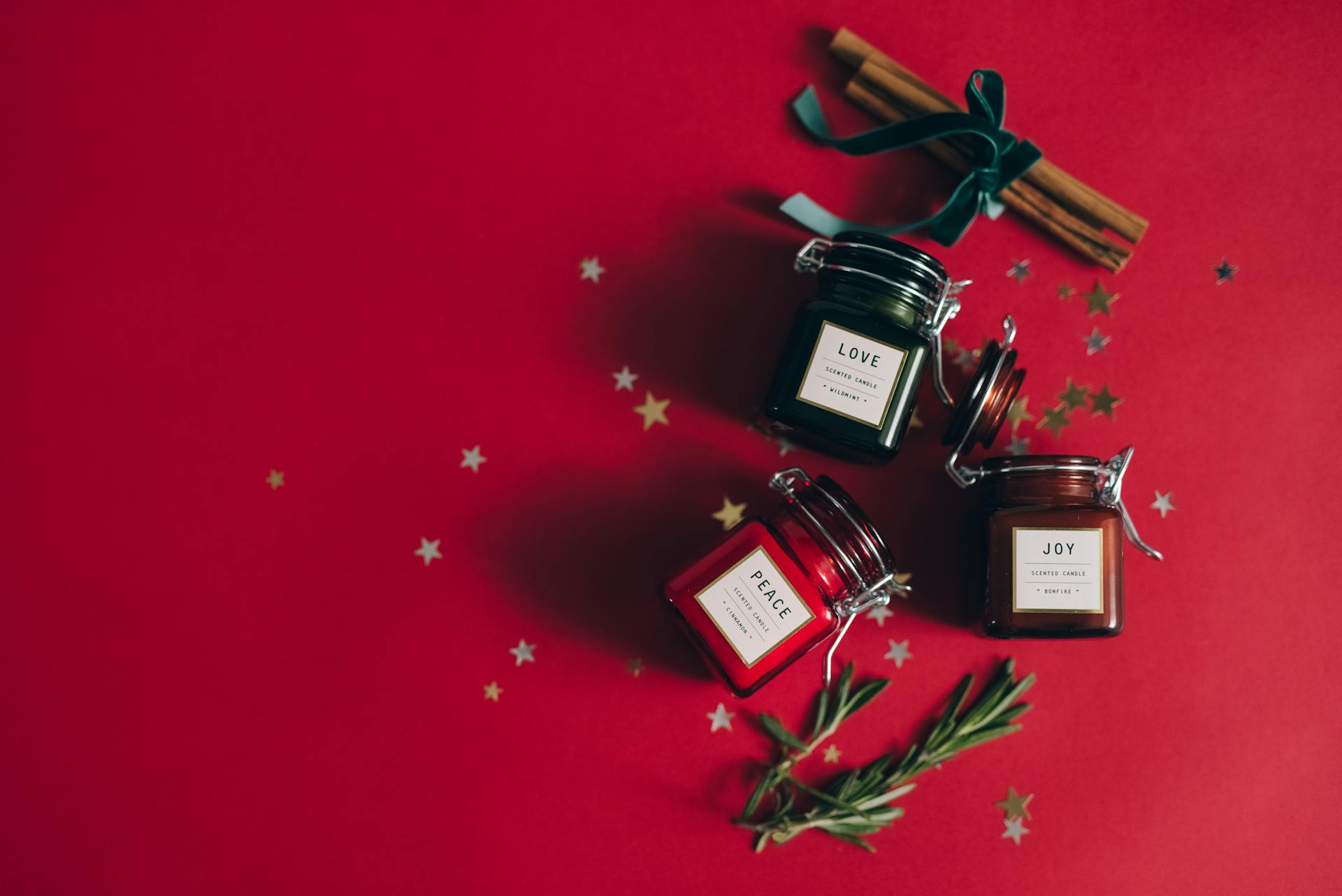 A festive flatlay with candles, cinnamon sticks, and Christmas décor.