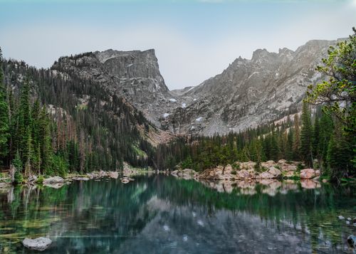 Free Peaceful mountain lake with surrounding peaks and forest in Cody, Wyoming. Stock Photo