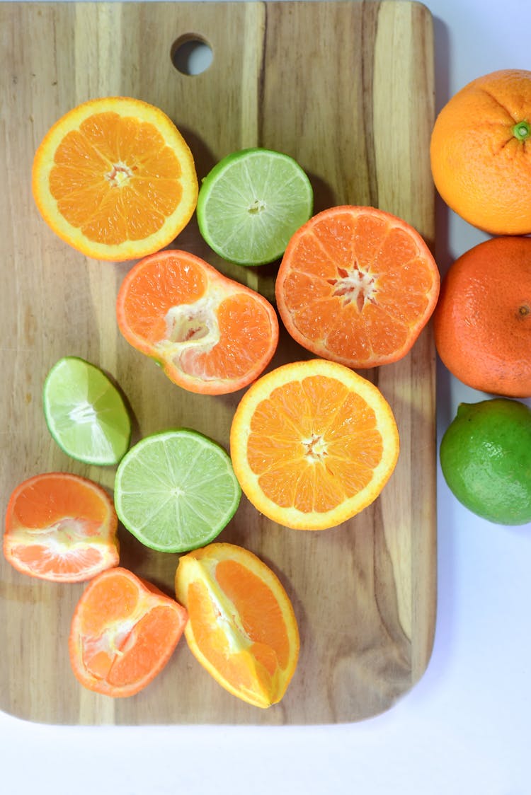 Oranges And Limes On Cutting Board