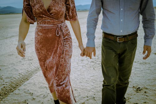 Free Woman in Pink Dress Holding Hands with Man in Blue Long Sleeve Shirt Stock Photo