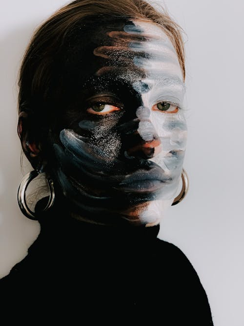 Serious model with painted face looking at camera