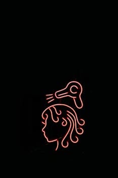 Fascinating neon sign depicting a hairdryer and head silhouette against a dark backdrop.