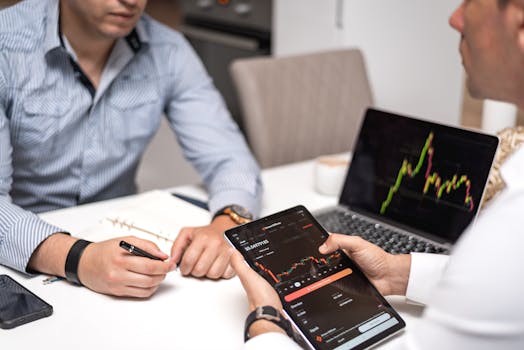 Two professionals discussing crypto trends using digital devices in an office setting.