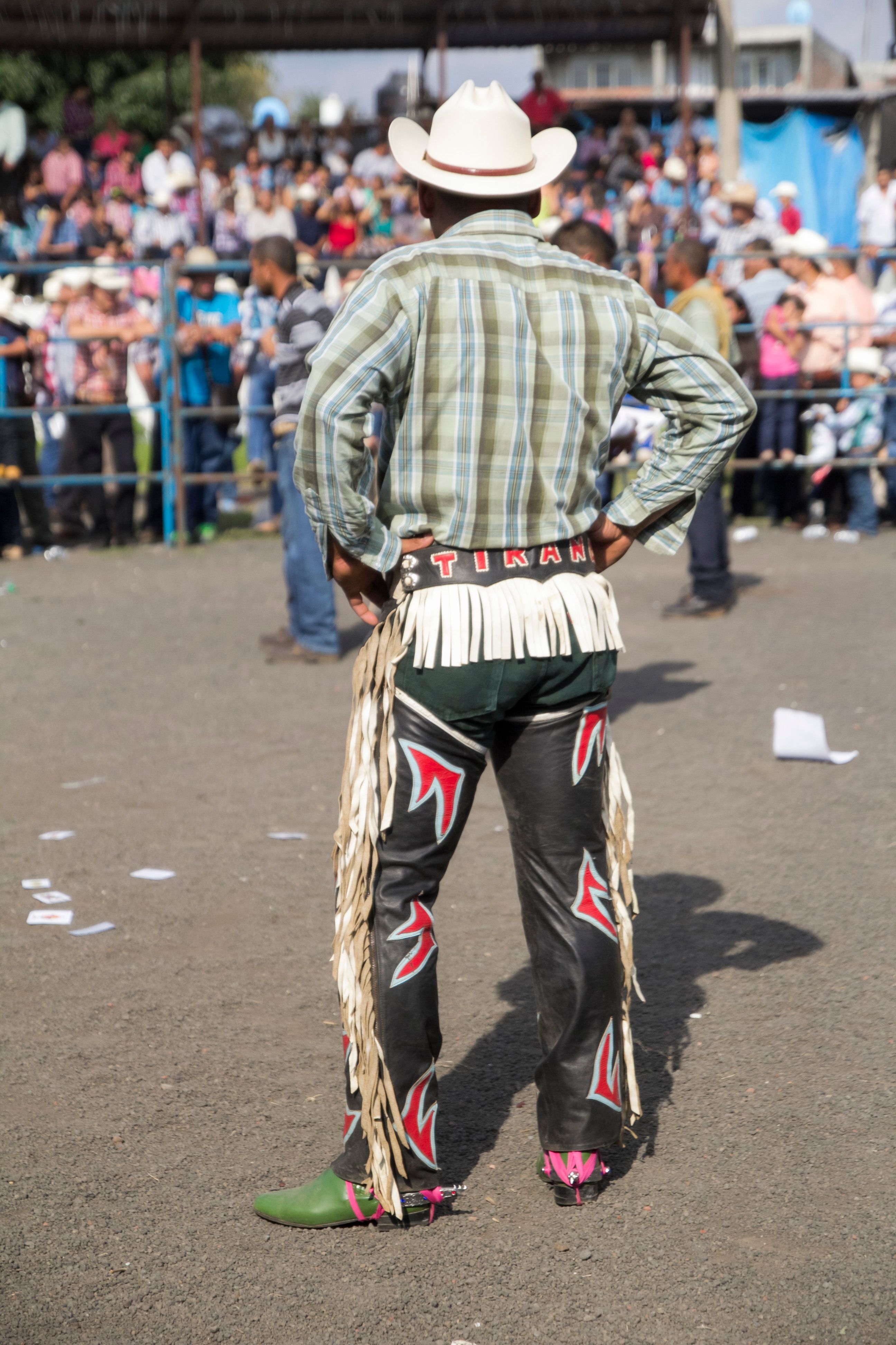 Back view of a cowboy in traditional attire at a Mexican rodeo, showcasing cultural heritage.