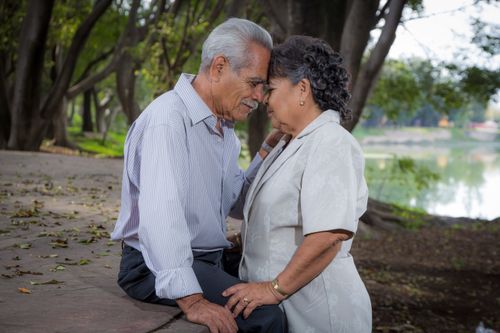 Free Senior couple enjoying a loving moment together outdoors in a serene park setting. Stock Photo