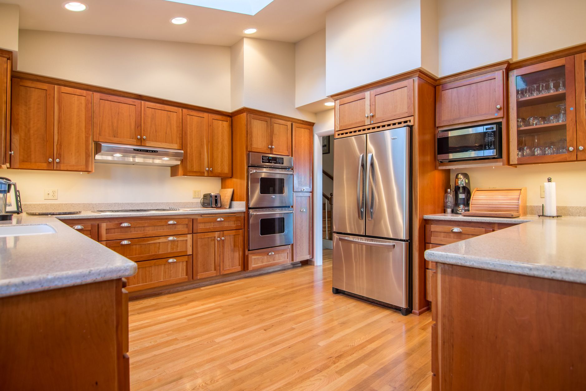 Bright kitchen with wooden cabinets and stainless steel appliances.
