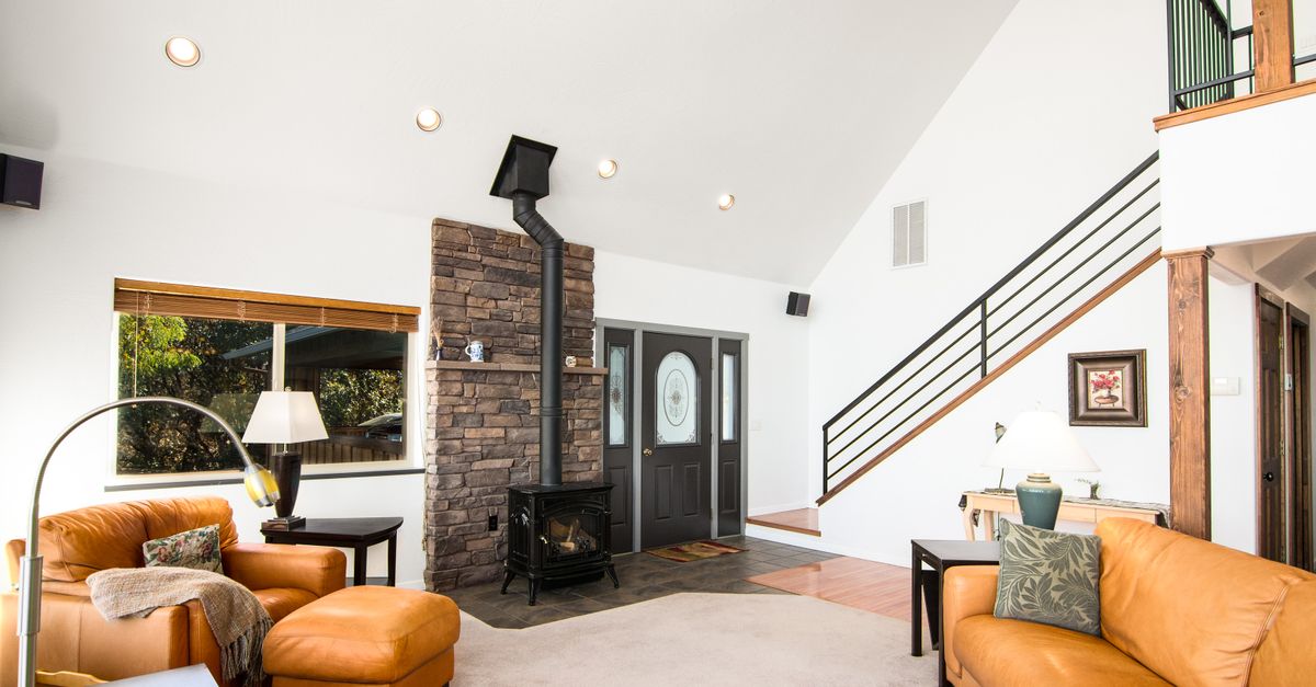 Bright and welcoming living room featuring a rustic fireplace and modern decor.