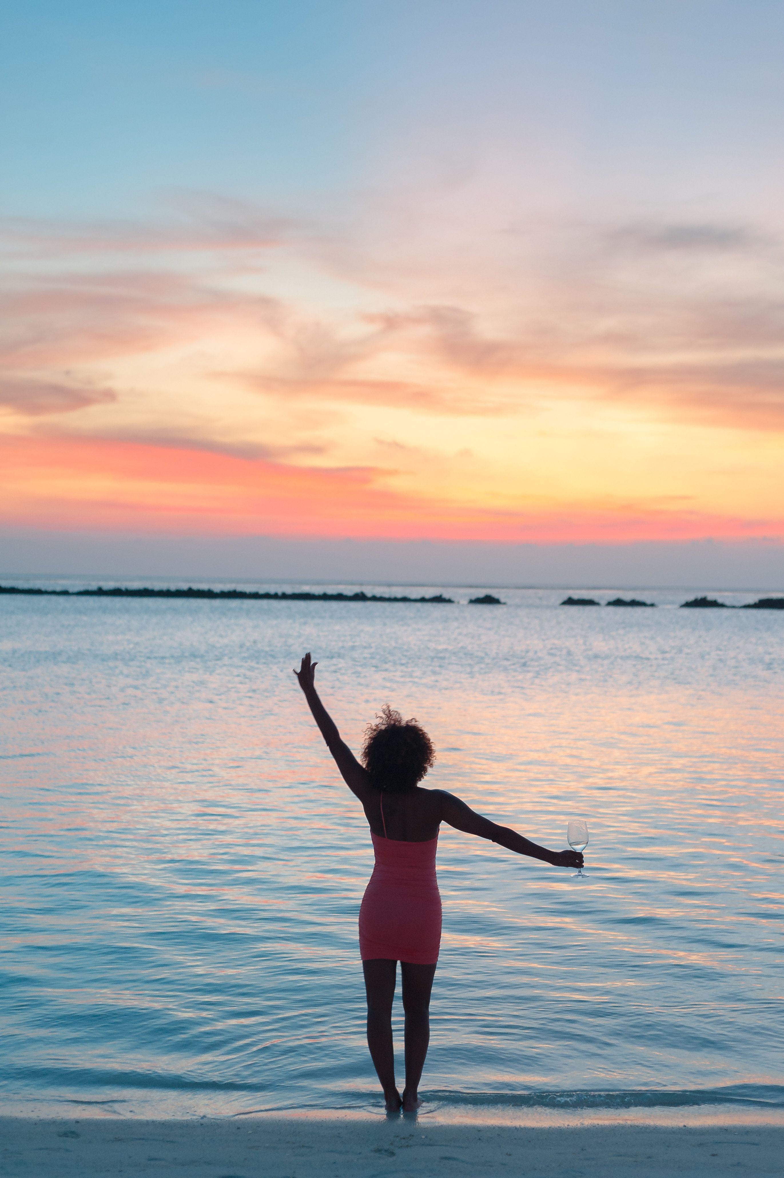 Woman in Pink Short Dress Standing on Beach Shore · Free Stock Photo