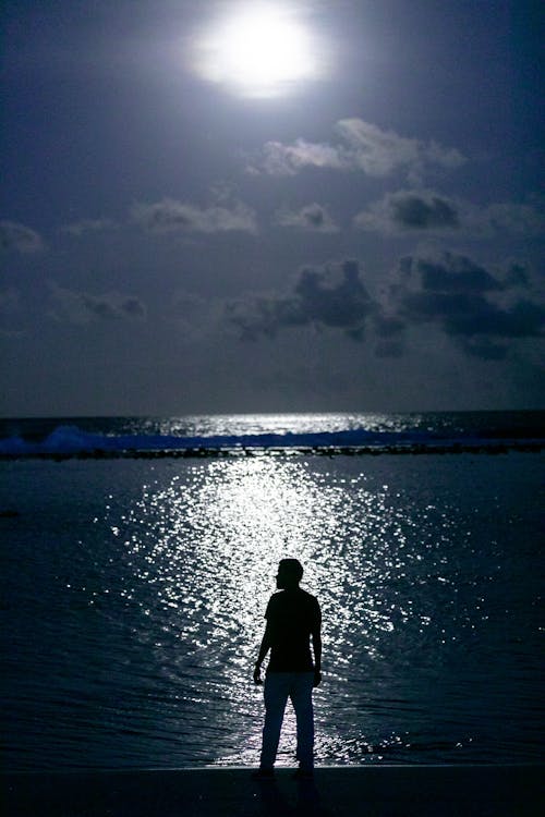 Silhouette of a Man Standing Near the Ocean