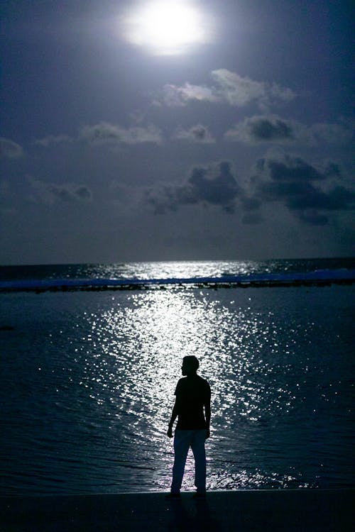 Silhouette of a Man Standing Near the Ocean