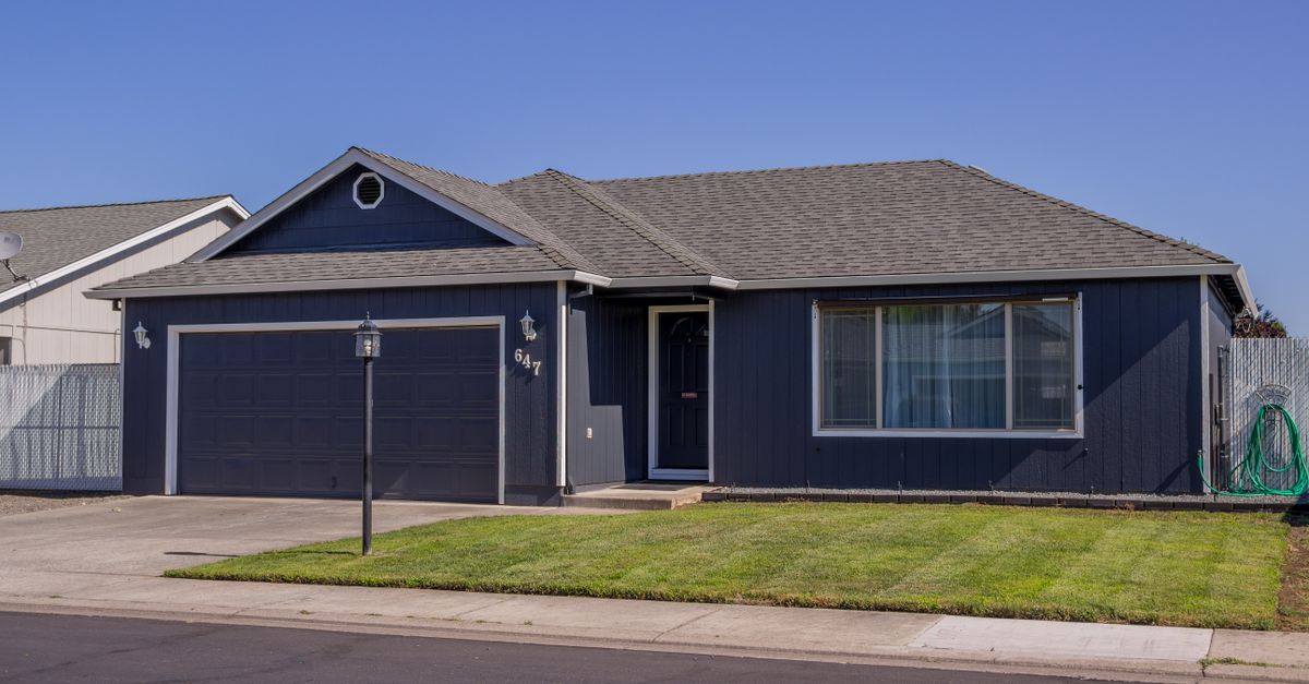 Charming suburban house with driveway, garage, and well-maintained lawn.