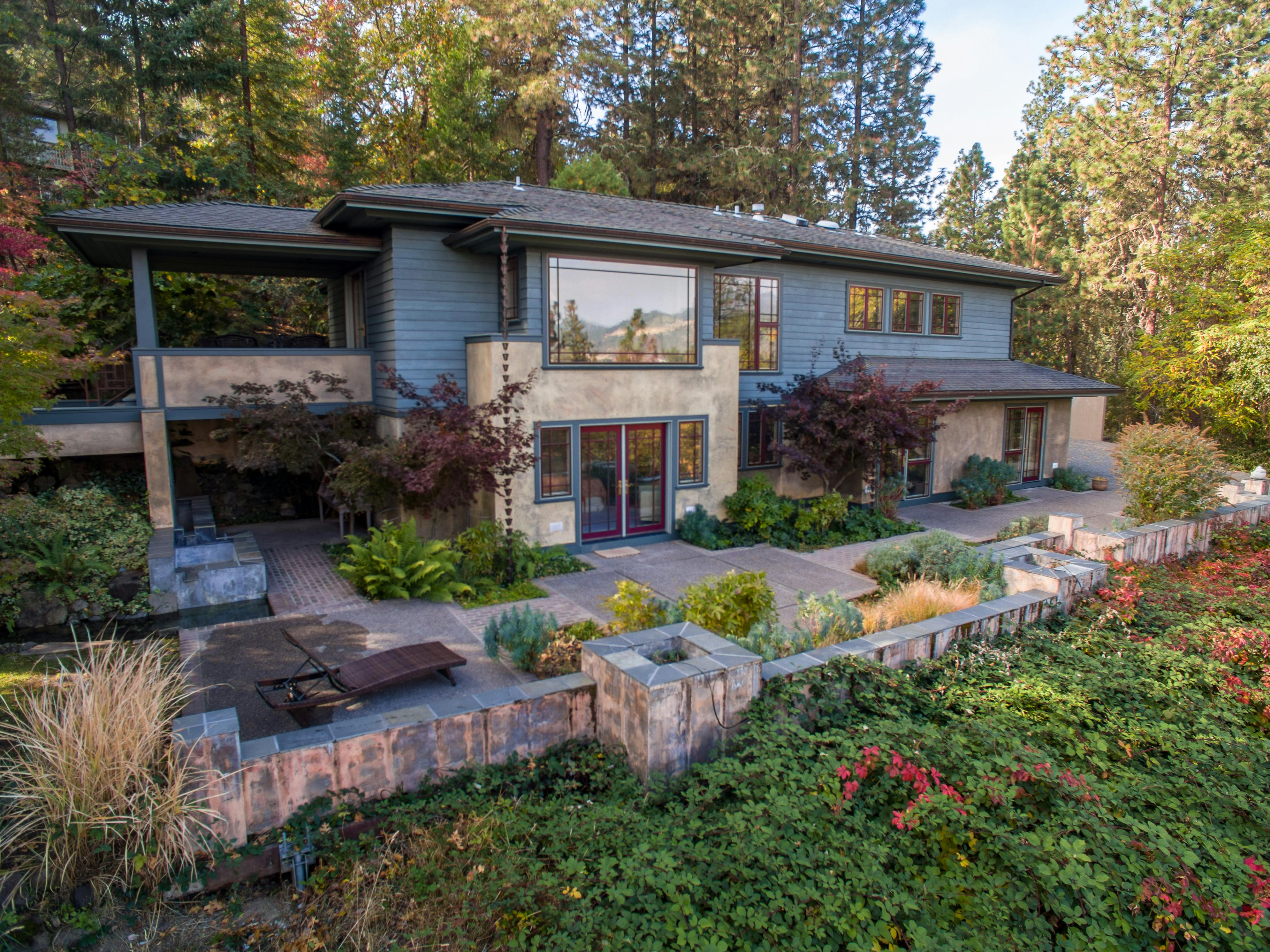Contemporary two-story house surrounded by a lush garden, showcasing a stunning facade.
