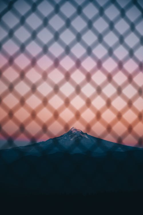 Mountain landscape through fence in evening